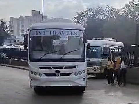 White shuttle bus from the fleet arriving at a pick-up point