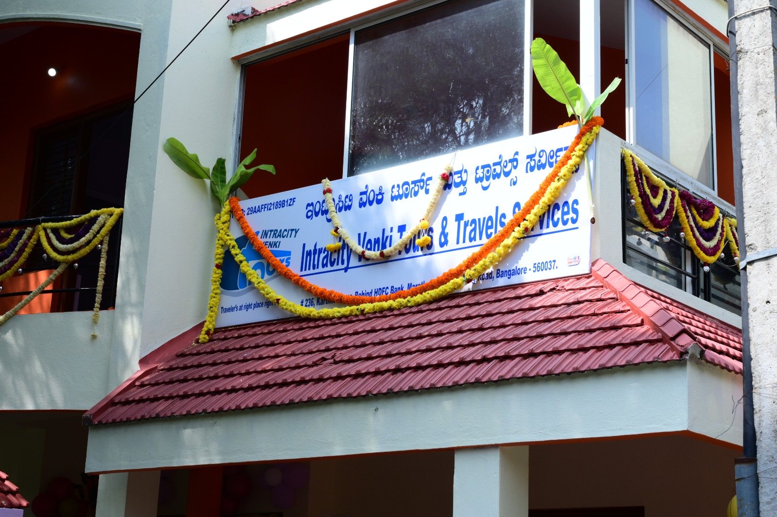 Intracity Venki Tours & Travels Services office signboard decorated with flowers